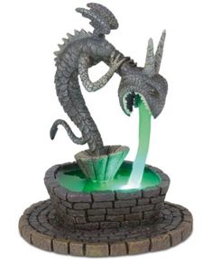 a statue of a dragon drinking out of a fountain with water coming out of it