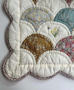 a close up of a quilted placemat with flowers and umbrellas on it