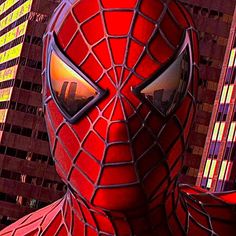 the amazing spider - man is in front of some tall buildings with his eyes wide open