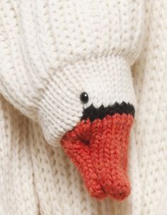 a white sweater with a red and black duck head on it's back pocket