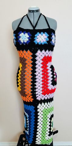 a crocheted dress is displayed on a mannequin's head stand