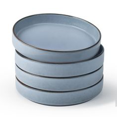 four blue dishes stacked on top of each other with brown rims in the middle