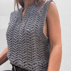 a woman wearing a gray knitted vest