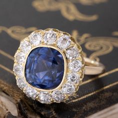 This Victorian component lived its' first life as the centerpiece to a fabulous antique bangle which didn't see much daylight, as one doesn't tend to wear big diamond cluster bangles everyday! We felt she was too beautiful to be couped up as such, so we added a simple gold shank to that center and this beautiful sapphire and old mine cut diamond cluster ring was born!The center has been designated by the UK's Gemological Certification Services as a Ceylon, no-heat sapphire with an estimated weig Vintage Sapphire Jewelry With Brilliant Cut, Vintage Sapphire Diamond Ring With Single Cut Diamonds, Exquisite Cluster Rings With Single Cut Diamonds, Heirloom Jewelry With Rose Cut Diamonds In Cluster Shape, Heirloom Diamond Jewelry With Halo Setting, Sapphire Diamond Ring With 17 Jewels For Wedding, Exquisite Cluster Rings With Rose Cut Diamonds, Luxury Rose Cut Diamond Cluster Jewelry, Luxury Rose Cut Cluster Diamond Jewelry