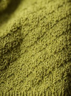 a close up view of a green knitted blanket