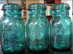 three blue mason jars sitting on top of a table