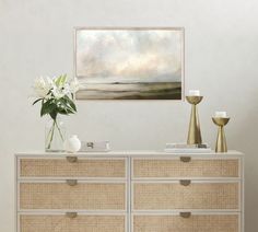 a painting hanging on the wall above a dresser