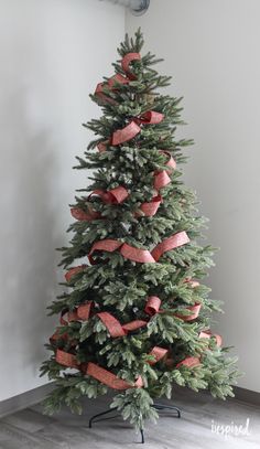 a small christmas tree with red bows on it