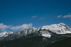 the mountains are covered in snow under a blue sky