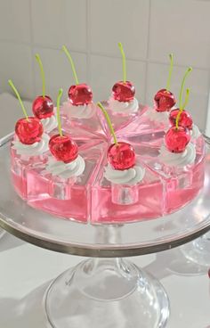 a cake with cherries on top is sitting on a glass platter, ready to be served