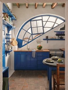 a kitchen with blue cabinets and shelves on the wall