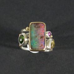 Tourmaline & opal swirled gold silver ring, Four stone band ring Unique Multicolor Opal Gemstone Ring, Multicolor Opal Multi-stone Rings, Unique Multi-stone Opal Rings, Unique Opal Rings With Gemstone Accents, Unique Opal Ring With Gemstone Accents, Unique Multicolor Cabochon Opal Ring, Cabochon Rings, Boulder Opal Jewelry, Modern Rings