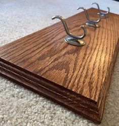 a wooden board with two metal hooks on the top and one is made out of wood