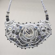 This silver statement necklace is the biggest and most extravagant textile necklace. A collier femme is made for a special occasion. Abstract shape filled with small circles and ribbon layers creates a new look and exclusive fiber artwork piece. At least the graphite grey and pearl color beads as a final touch were added. I created this original statement necklace using my beloved grey, silver, and white colors which add a waft of elegance and chick. This fiber art jewelry piece is a perfect gif Handmade Silver Beaded Necklaces For Party, Elegant Handmade Metal Bib Necklaces, Unique Silver Beads Necklace, Unique Handmade Bib Necklace, Elegant Handmade Metal Bib Necklace, Handmade Silver Necklace In Wearable Art Style, Handmade Silver Beaded Necklaces For Evening, Silver Handmade Beaded Necklaces For Evening, Handmade Metal Bib Necklace For Party