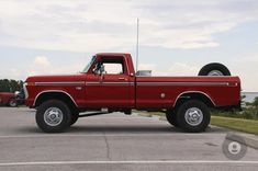 a red pickup truck parked in a parking lot