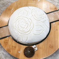 a cake sitting on top of a wooden cutting board next to a knife and cookie