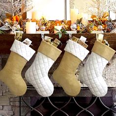 three stockings hanging from a fireplace with candles in the background