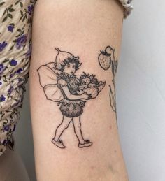 a small tattoo on the arm of a girl with flowers and a fairy holding a flower