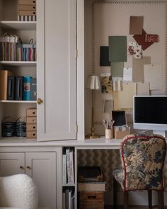 a desk with a computer, chair and bookshelf in front of the wall