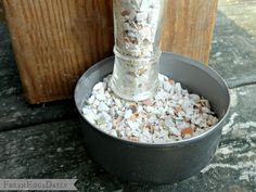 a metal container filled with gravel next to a wooden wall