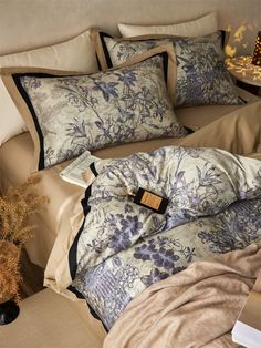 the comforter is made up with blue and white flowers on it, along with pillows