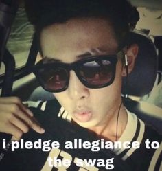 a young man wearing sunglasses in the back seat of a car, making a funny face and saying i pledge allegiance to the swag