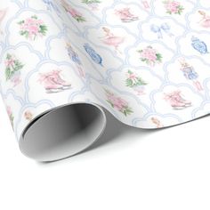 a white wrapping paper with pink and blue flowers on the top, next to an empty roll