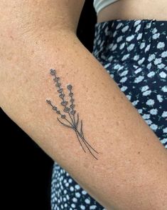 a close up of a person's arm with a flower tattoo on it