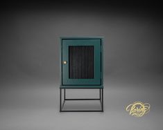 a small green cabinet sitting on top of a metal stand in front of a gray background