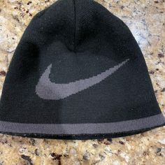 a black nike beanie sitting on top of a counter