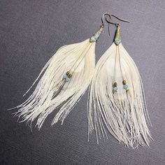 White feather earrings offer a stunning piece of bohemian statement jewelry, perfect for a bride seeking spiritual guidance on her special day. These long statement earrings make a meaningful gift for women, ideal for a wedding or other memorable occasions. You may request smaller or larger feathers in the notes section of your order. 🪶 𝗠𝗔𝗧𝗘𝗥𝗜𝗔𝗟𝗦 + 𝗗𝗜𝗠𝗘𝗡𝗦𝗜𝗢𝗡𝗦 ❯  Earrings measure 3-1/2 to 4 inches long ❯  Swarovski Crystal, Hematite, Brass French Earring Wire 🪶 𝗦𝗧𝗢𝗡𝗘 + 𝗘𝗟𝗘𝗠𝗘𝗡𝗧 𝗘𝗡𝗘𝗥𝗚𝗬 ❯  FEATHERS symbolize our divine guidance ❯  HEMATITE is known to foster peace and stability 🪶 𝗣𝗘𝗥𝗦𝗢𝗡𝗔𝗟𝗜𝗭𝗔𝗧𝗜𝗢𝗡 + 𝗚𝗜𝗙𝗧 𝗦𝗘𝗧 𝗦𝗨𝗚𝗚𝗘𝗦𝗧𝗜𝗢𝗡𝗦 ❯  Toggle Bracelet (photo 8) -- lorenlavinedesigns.etsy.com/listing/1052937100 ♻️  𝗘𝗖𝗢-𝗙𝗥𝗜𝗘𝗡𝗗𝗟? White Feather Dangle Earrings, Bohemian White Chandelier Earrings For Festivals, Bohemian White Tassel Earrings For Pierced Ears, Elegant Adjustable Feather Earrings, Bohemian Tassel Dangle Earrings For Wedding, Adjustable White Feather Jewelry, Elegant Adjustable Tassel Earrings For Festivals, Elegant Feather Earrings, Bohemian Adjustable Wedding Earrings