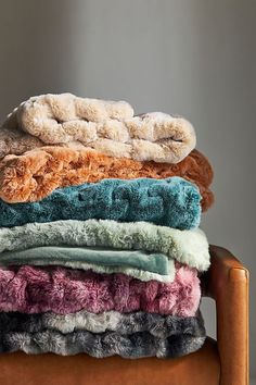 a stack of blankets sitting on top of a wooden chair