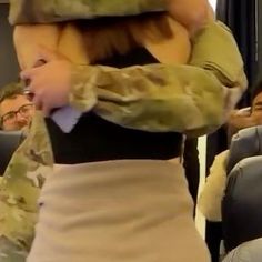 a woman in a skirt is carrying a stuffed animal over her head while others sit on the bus