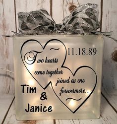 a lighted glass block with two hearts and the words tim & janice on it