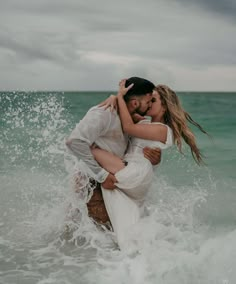 a man and woman embracing in the ocean