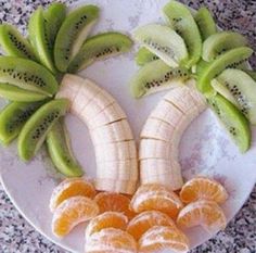 a plate topped with sliced kiwis and oranges on top of a counter