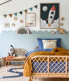 a bedroom with blue walls and artwork on the wall