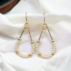 Make a statement with Lane - Gold & Pearl Luster! These 14k Gold filled teardrop hoop earrings featuring beautiful pearl luster seed beads will guarantee you some serious style points. Perfect for a fun night out! Approximately 1.75” long Made with 14k Gold Filled wire Glass Miyuki Seed Beads Polished to a high shine Handmade in Montana Sent in a ribboned gift box with polishing cloth