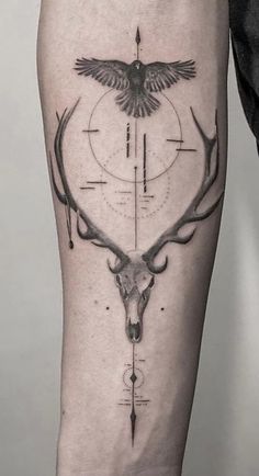 a man with a tattoo on his leg that has a deer's head and arrows