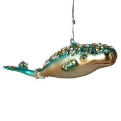 a glass ornament shaped like a fish with beads on it's tail