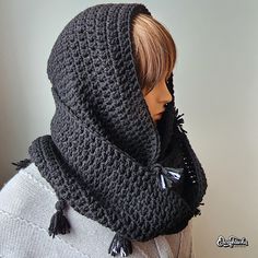 a mannequin wearing a gray crocheted hat and scarf with tassels