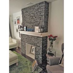 a living room filled with furniture and a stone fireplace