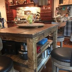 the kitchen island is made out of wood and has two stools in front of it