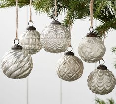 four ornaments hanging from a christmas tree