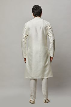 Raw Silk Kurta with thread and gold sequence embroidered in the fabric plus gold churidar Crafted with a collar neckline, full sleeves, and front button closure. Occasion: Can be worn to lighter events like Sangeet, Mehendi, Puja, or a small party WASH CARE INSTRUCTIONS - Please Dry clean only when it is applicable. Slight color variation is possible due to digital photography. Embroidered Long Sleeve Churidar For Wedding, Elegant Churidar With Dabka Work, Elegant Long Sleeve Churidar With Zari Work, Elegant Long Sleeve Zari Work Churidar, White Long Sleeve Churidar For Wedding, Traditional Formal Kurta With Embroidered Sleeves, Fitted Long Sleeve Nehru Jacket With Chikankari Embroidery, White Long Sleeve Churidar For Festivals, Fitted Nehru Jacket With Embroidered Sleeves