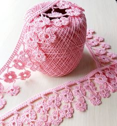 a roll of pink crocheted ribbon on a table