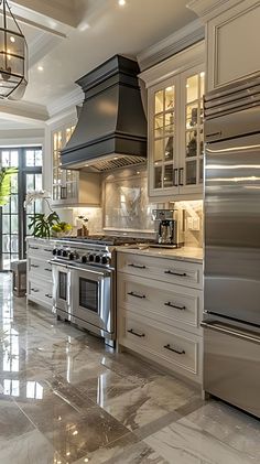 a large kitchen with marble floors and stainless steel appliances, along with glass doors that lead to an outdoor patio