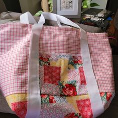 a pink and white bag sitting on top of a couch