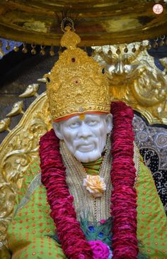 a statue with a crown on top of it in front of a gold and red object