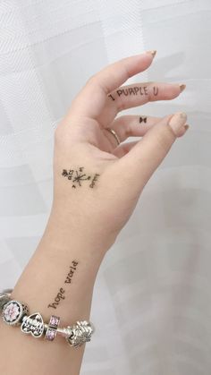 a woman's hand with tattoos on it and the word purple written in small letters